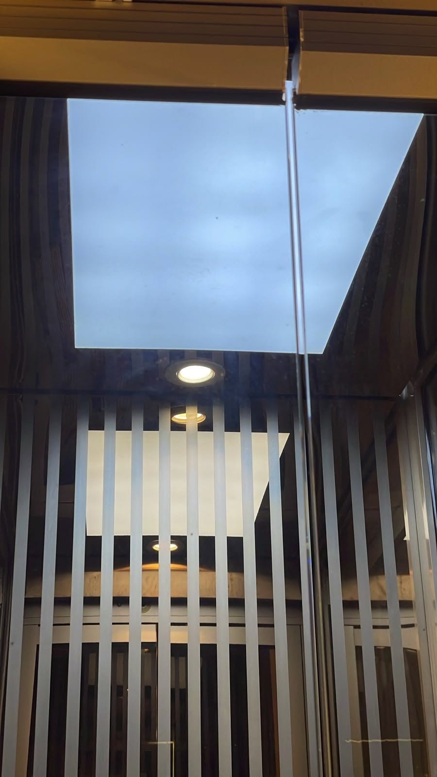 Looking up inside the car: the lit ceiling panel over the slatted walls